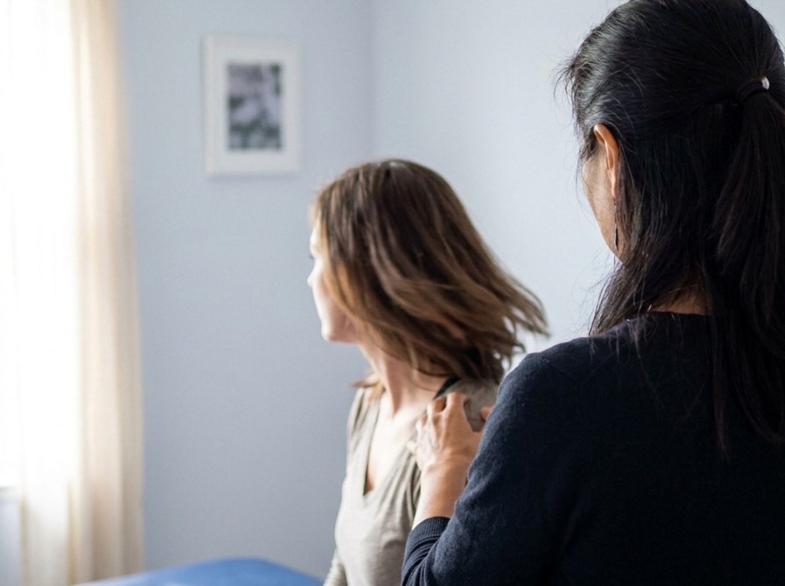 Dr. Bae behind a patient turning her head on the treatment table in Sunnyvale